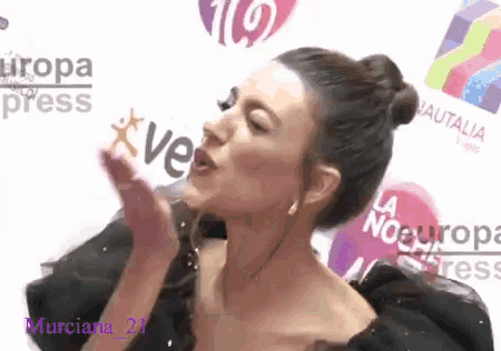 a woman blowing a kiss in front of a sign that says la noeuropa