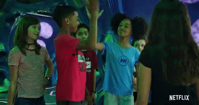a group of children are giving each other a high five in front of a netflix sign .