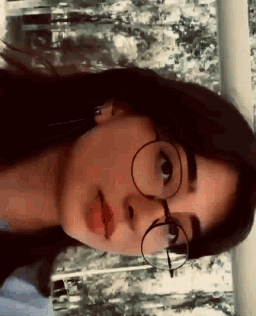 a close up of a woman wearing glasses and red lipstick .