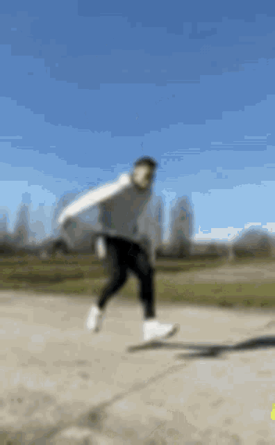 a man is jumping in the air while riding a skateboard on a sidewalk .