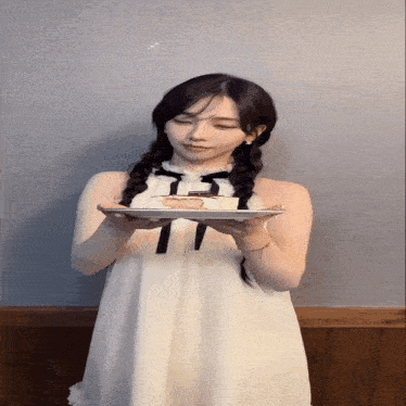 a woman in a white dress holds a plate of food
