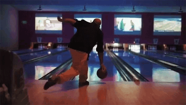 a man throws a bowling ball in a bowling alley with the number 7 on the wall