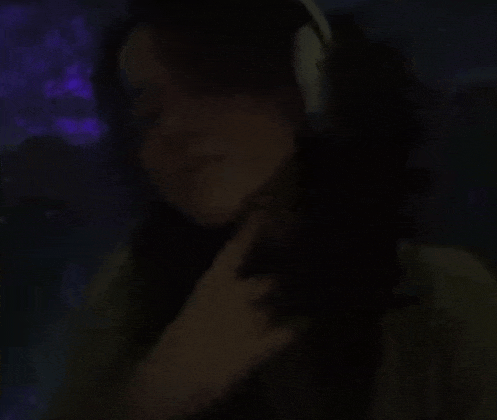 a woman wearing headphones in a dark room .