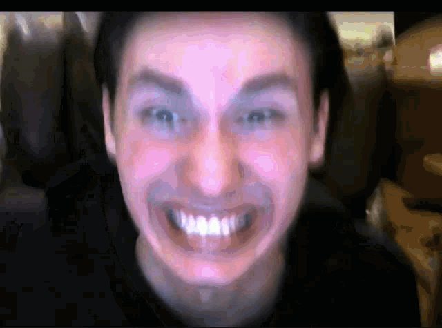 a close up of a man 's face with a big smile on it
