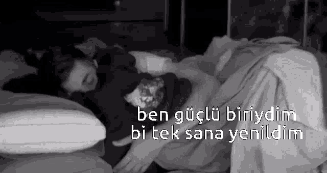 a black and white photo of a person laying on a bed with a foreign language .