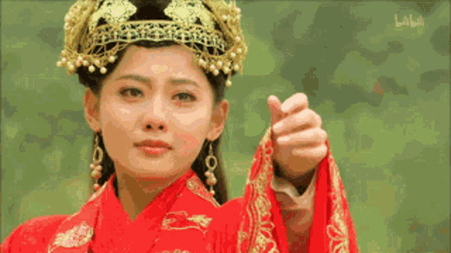 a woman wearing a red and gold costume and a crown