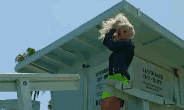 a woman stands in front of a lifeguard off duty sign