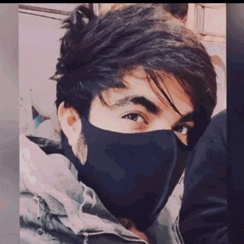 a young man wearing a black mask covering his face