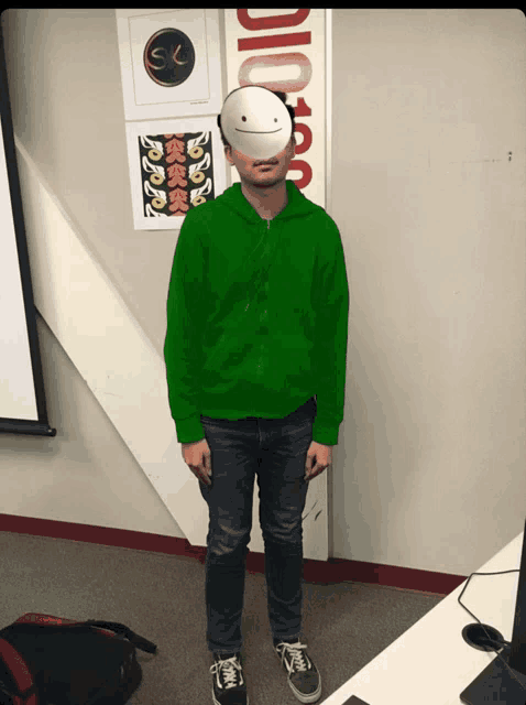 a man wearing a green hoodie and a white mask stands in front of a sign that says dio