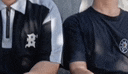 a couple of men are sitting next to each other wearing matching shirts .