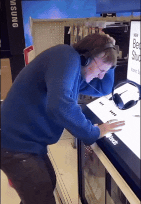 a man wearing headphones is looking at a sign that says best stud