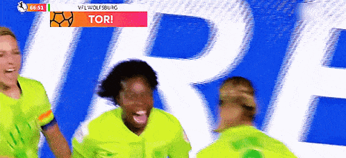 a group of soccer players are celebrating a goal in front of a banner that says tor