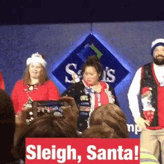 a group of people are standing in front of a sam 's club sign