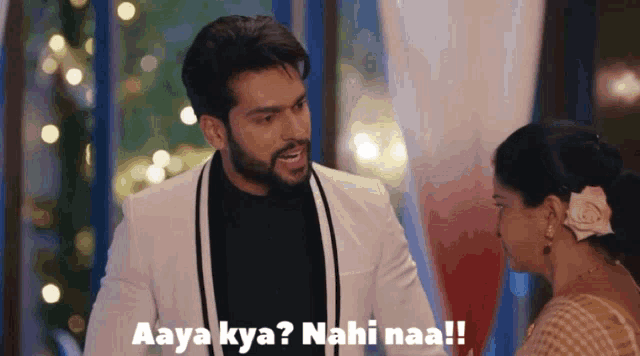 a man in a white suit is talking to a woman with the caption aaya kya nahi naa !