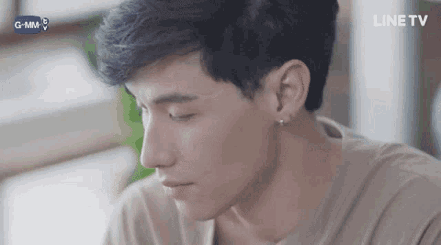 a close up of a young man 's face with a line tv logo in the background .
