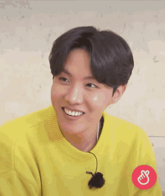a close up of a person wearing a yellow sweater with chinese writing on it
