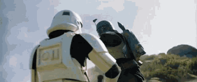 a storm trooper and a boba fett are fighting each other in a desert .