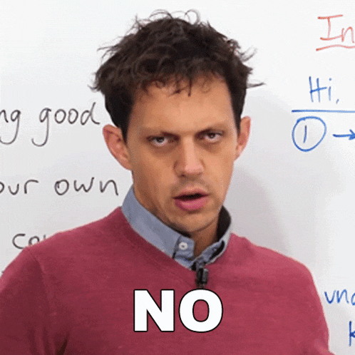 a man in a red sweater says " no " in front of a white board