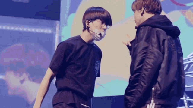 two men are standing next to each other and one has a mask on his face