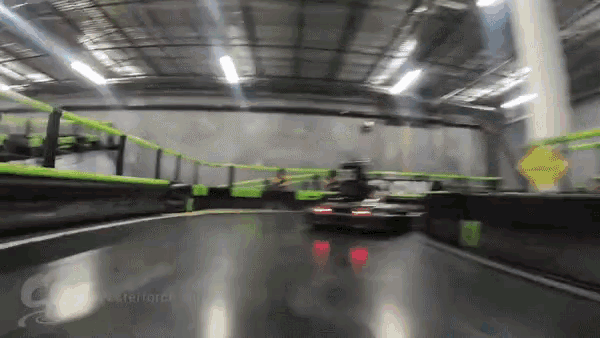 a blurred image of a go kart track with a yellow sign in the background that says ' nexterlator '