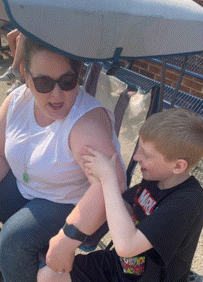 a boy wearing a marvel t-shirt is sitting next to a woman