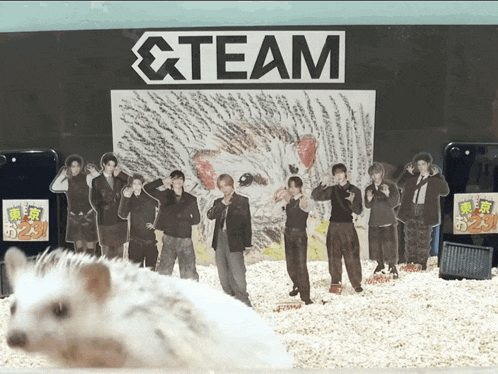 a group of people are standing in front of a sign that says & team
