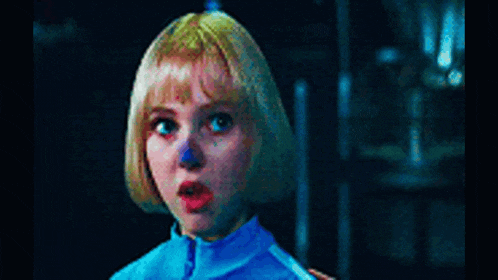 a little girl with blonde hair and a blue shirt is looking up at something .
