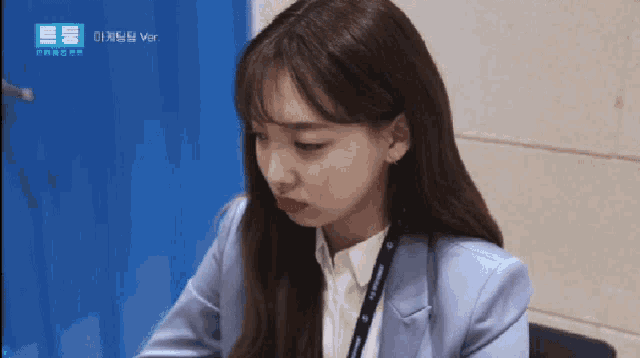 a woman with a lanyard around her neck is wearing a light blue jacket