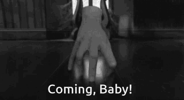 a black and white photo of a hand with the words " coming baby " below it