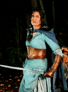 a woman in a blue dress is holding a sword in a dark forest