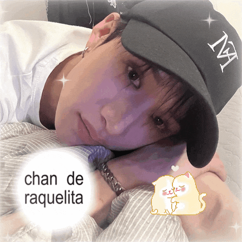 a man wearing a ny hat is laying on a bed with the words chan de raquelita below him