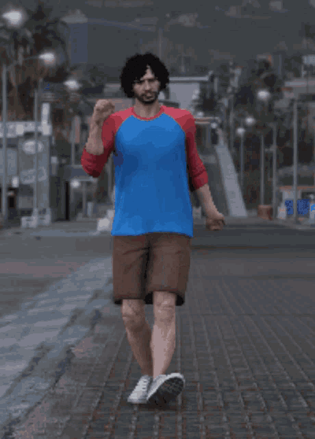 a man in a blue shirt and brown shorts stands on a sidewalk