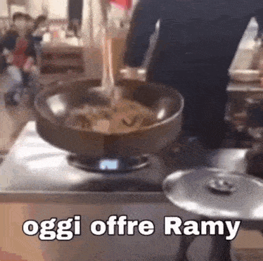 a person is cooking food in a pan on a stove with the words oggi offre ramy written on the bottom .