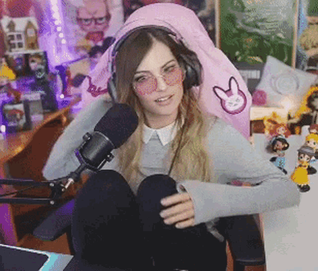 a woman wearing headphones and sunglasses is sitting in front of a microphone