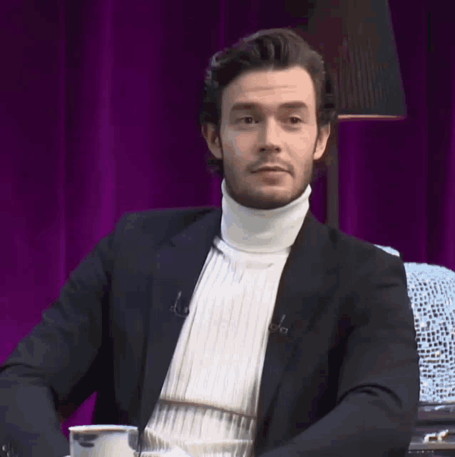 a man wearing a turtleneck and a black jacket