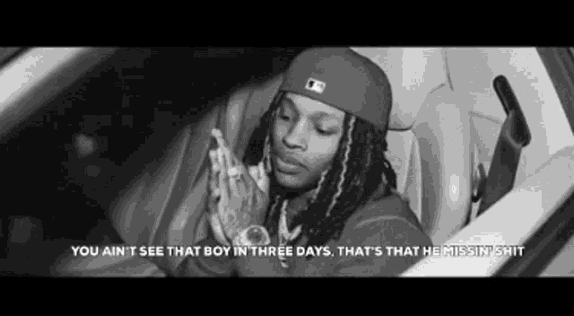 a black and white photo of a man sitting in a car with the caption " you ain t see that boy in three days