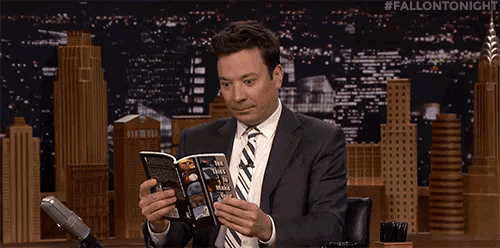 a man in a suit and tie is reading a book on a show .