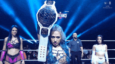 a woman in a wrestling ring holding a championship belt that says " vengeance "