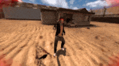 a man in a black jacket is standing in the sand in front of a house