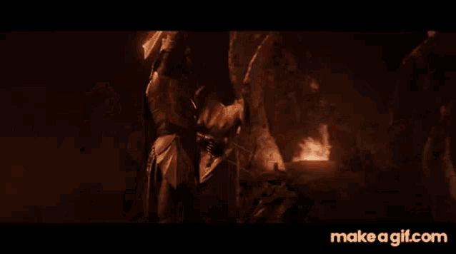 a man is holding a sword in a dark cave .