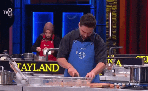 a man wearing a blue apron that says onur on it