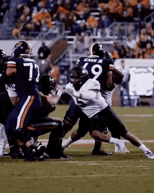a football player wearing a number 19 jersey is being tackled