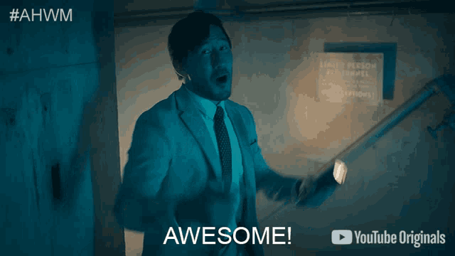 a man in a suit and tie is holding a flashlight and says awesome on the bottom