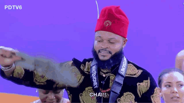 a man with a beard wearing a red hat and a lanyard that says ' whitemoney ' on it