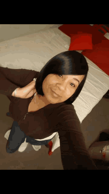 a woman takes a selfie in front of a bed