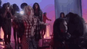 a group of people are dancing on a stage in a club .
