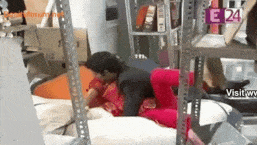 a man and woman are having sex in a room with a sign that says e 24