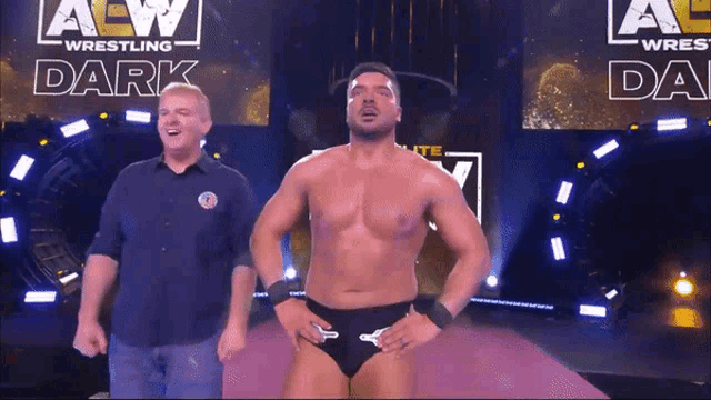 two men are standing in front of an aew wrestling dark sign