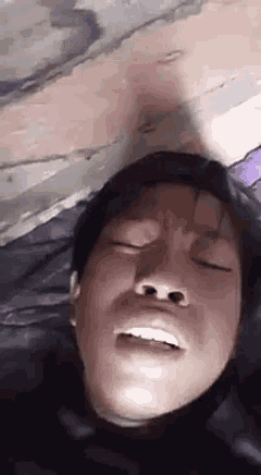 a close up of a person 's face with their eyes closed and their mouth open .