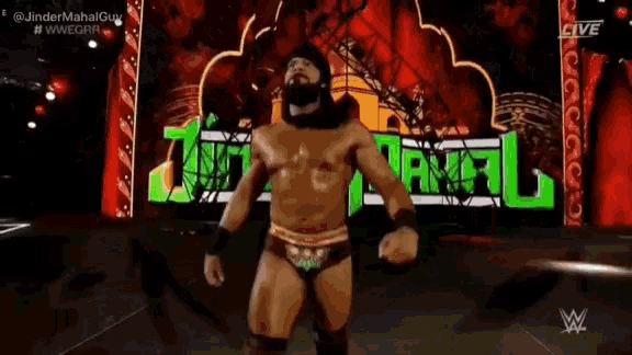 a wrestler with a beard is standing in front of a green sign that says death .
